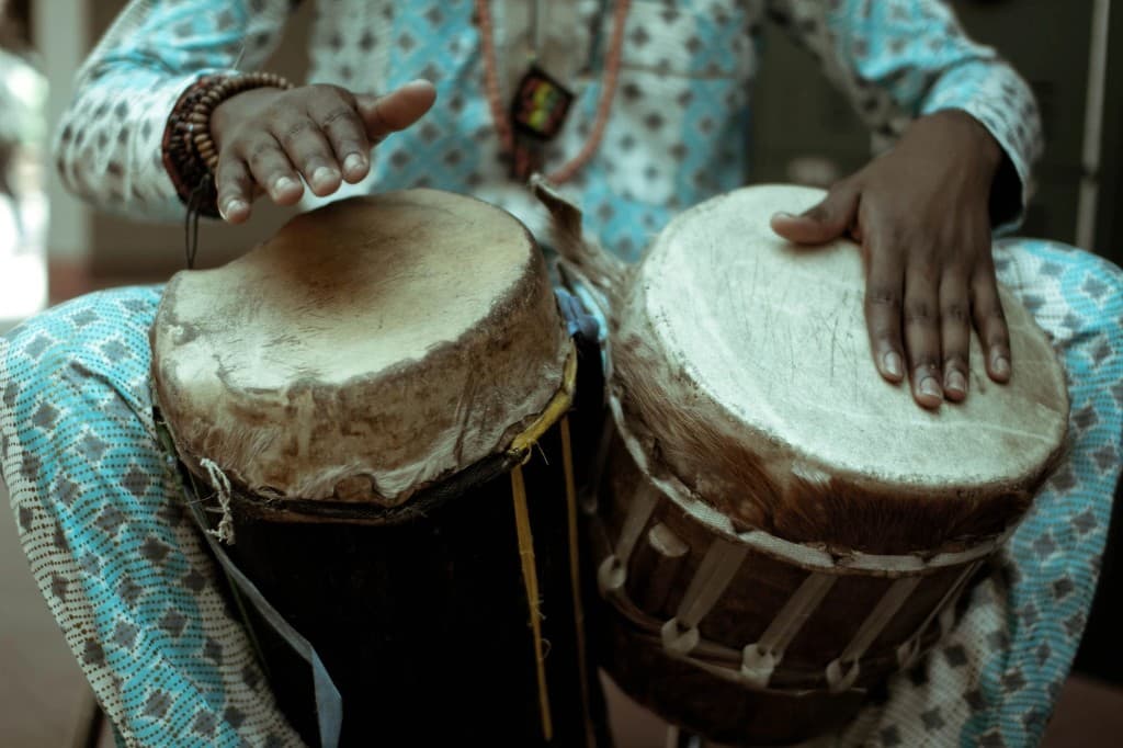 Two hands play a pair of talking drums.